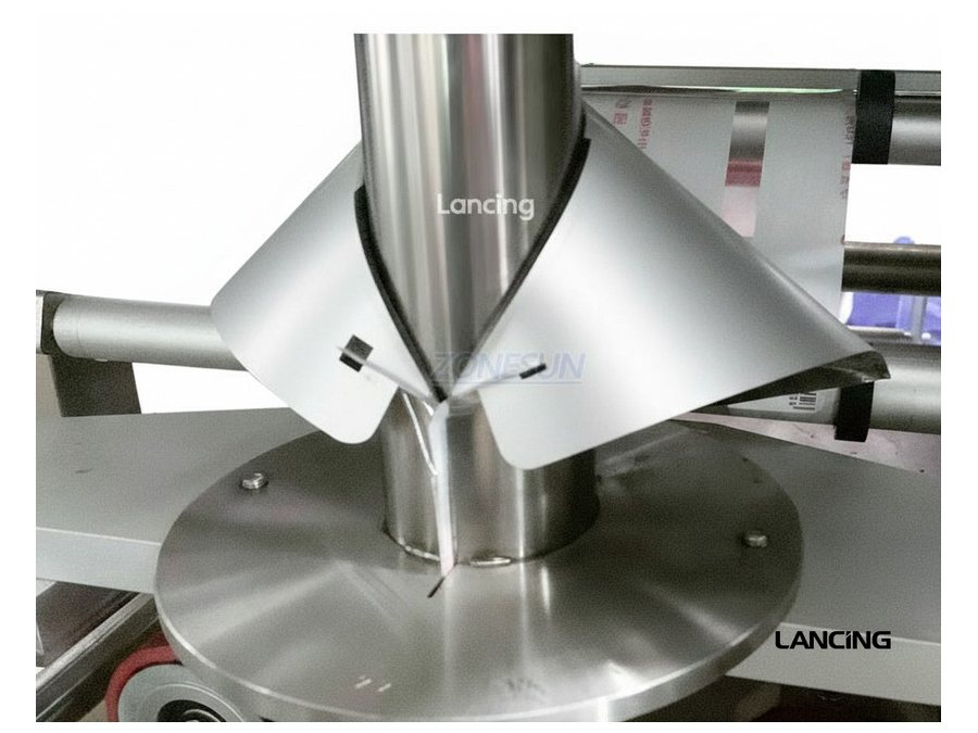 Close-up of a powder dosing chute and forming tube for dust-control planning